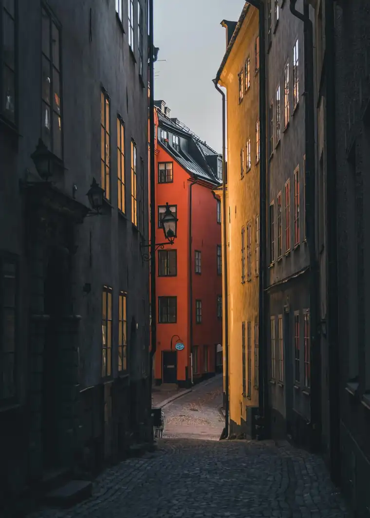 A narrow lane in Gamla Stan, Stockholm's Old Town, with ochre and red facades
